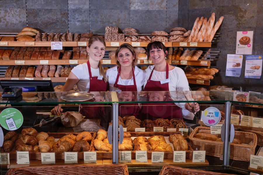 Drei Mitarbeiterinnen vom BioMarkt Bad Nauheim hinter der Auslage der Bäckerei im Supermarkt